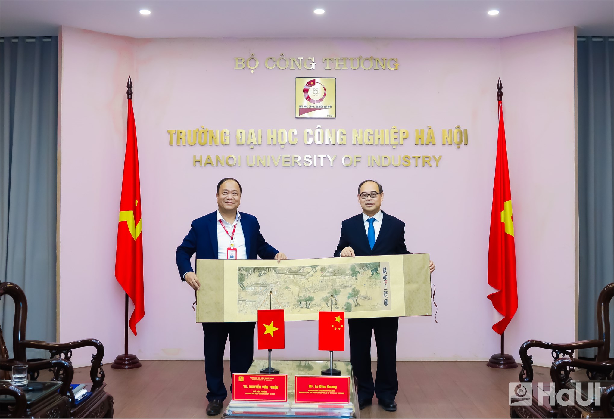 Ông La Diệu Quang tặng quà lưu niệm cho TS. Nguyễn Văn Thiện - Phó hiệu trưởng 